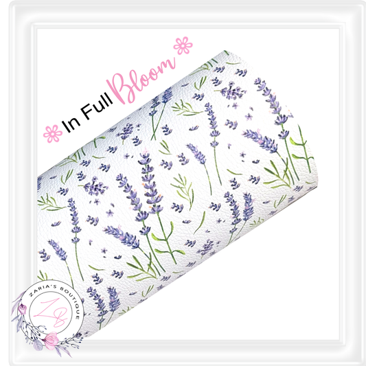 A roll of white faux leather with a delicate lavender and green botanical pattern, displayed diagonally with decorative text reading 'In Full Bloom' and a Zaria’s Boutique logo.